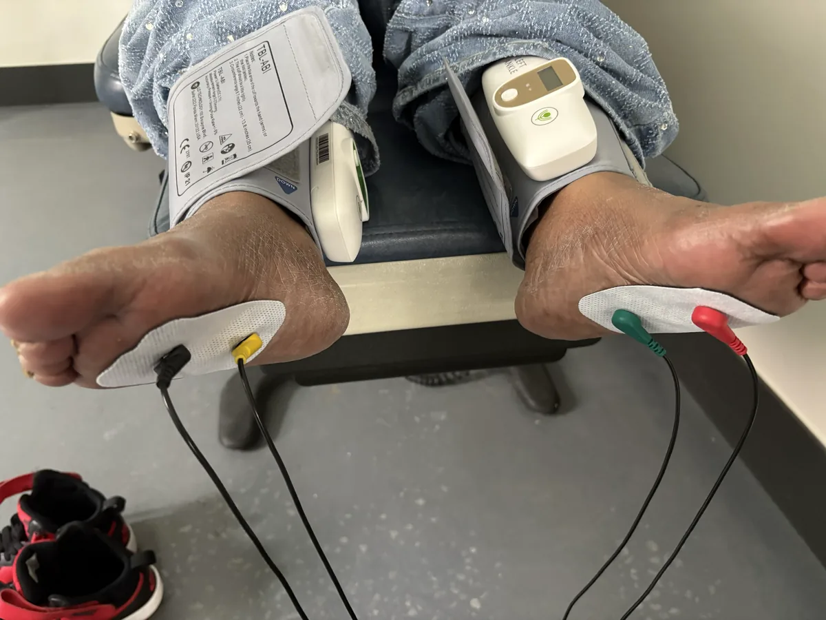Patient seated with ankle cuffs and foot electrodes in place for combined vascular and neuropathy testing at Regenerve, 4477 Woodson Rd #104, St. Louis, MO 63134
