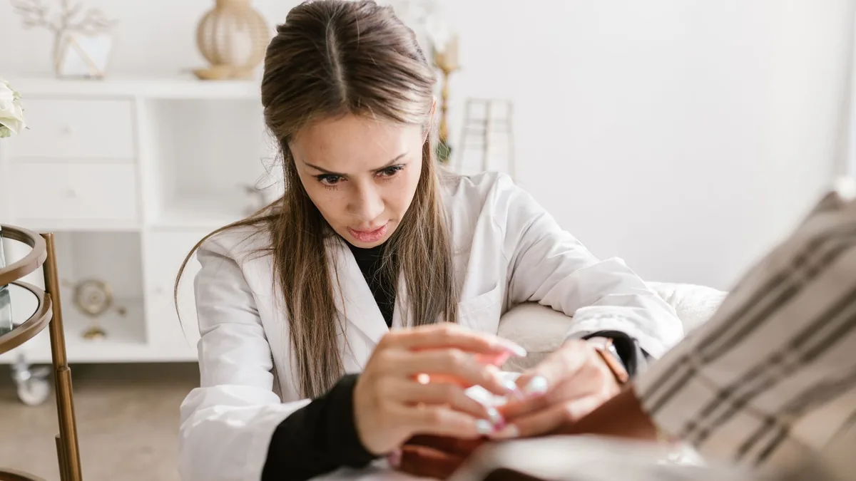 A concentrated female doctor providing medical care to a patient in a professional setting.