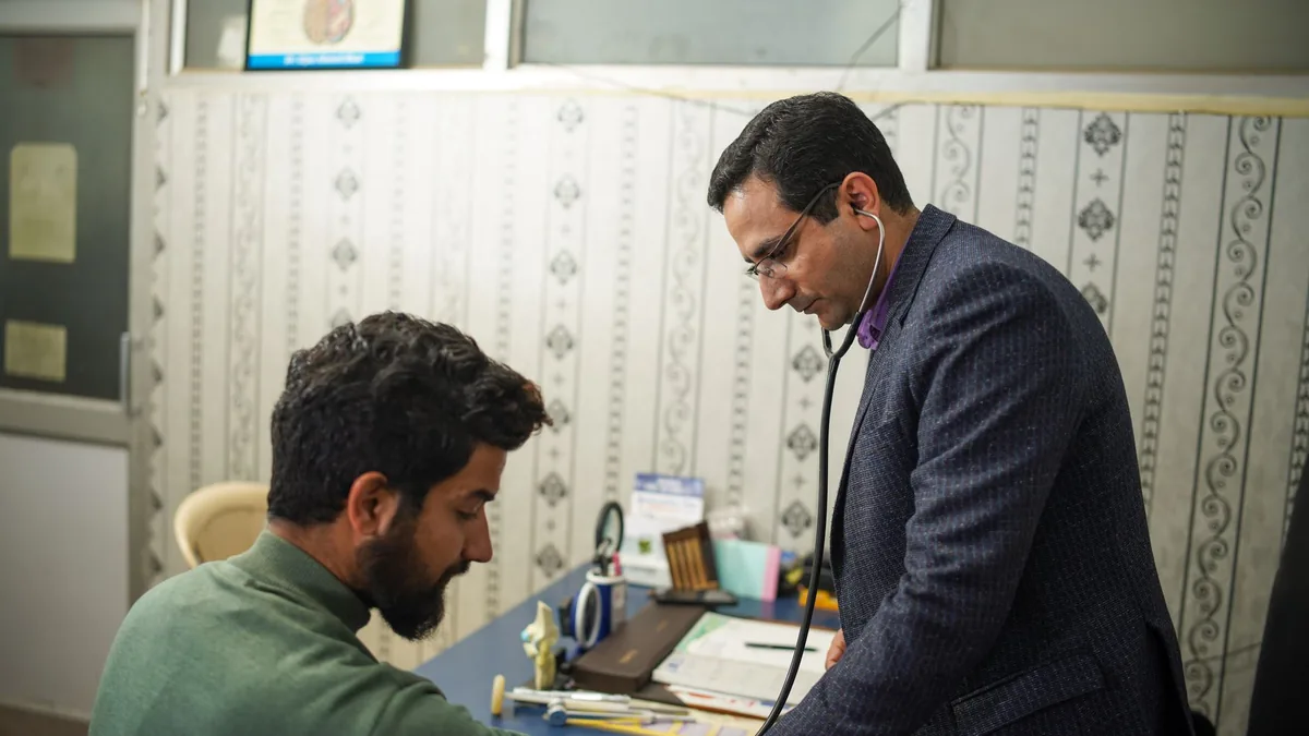 A doctor uses a stethoscope for a patient's health check-up in a clinic.