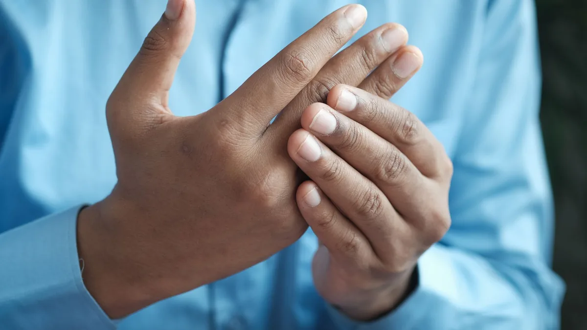 Close-up of a man gently holding his hand.