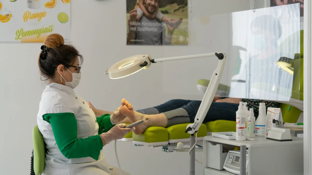A podiatrist provides foot care to a patient in a clinical setting.