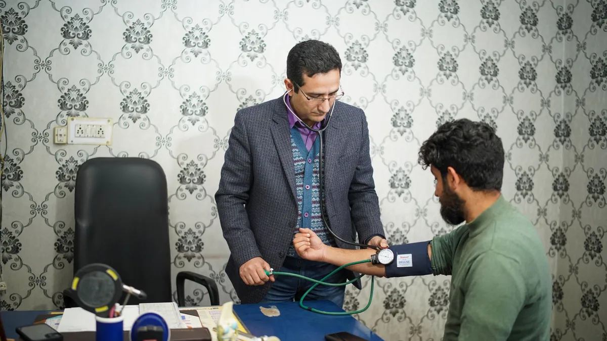 Doctor checking patient's blood pressure during medical consultation indoors.