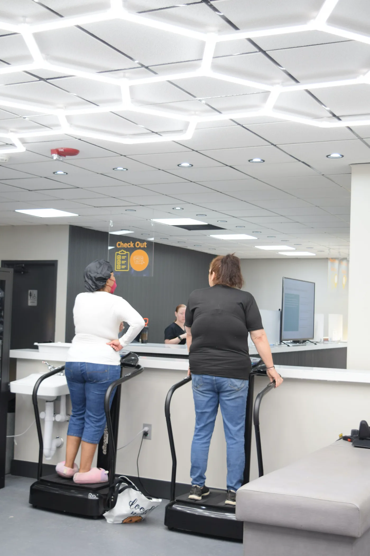 Two patients standing on whole-body vibration platforms in the therapy area at Regenerve, 4477 Woodson Rd, St. Louis, MO 63134