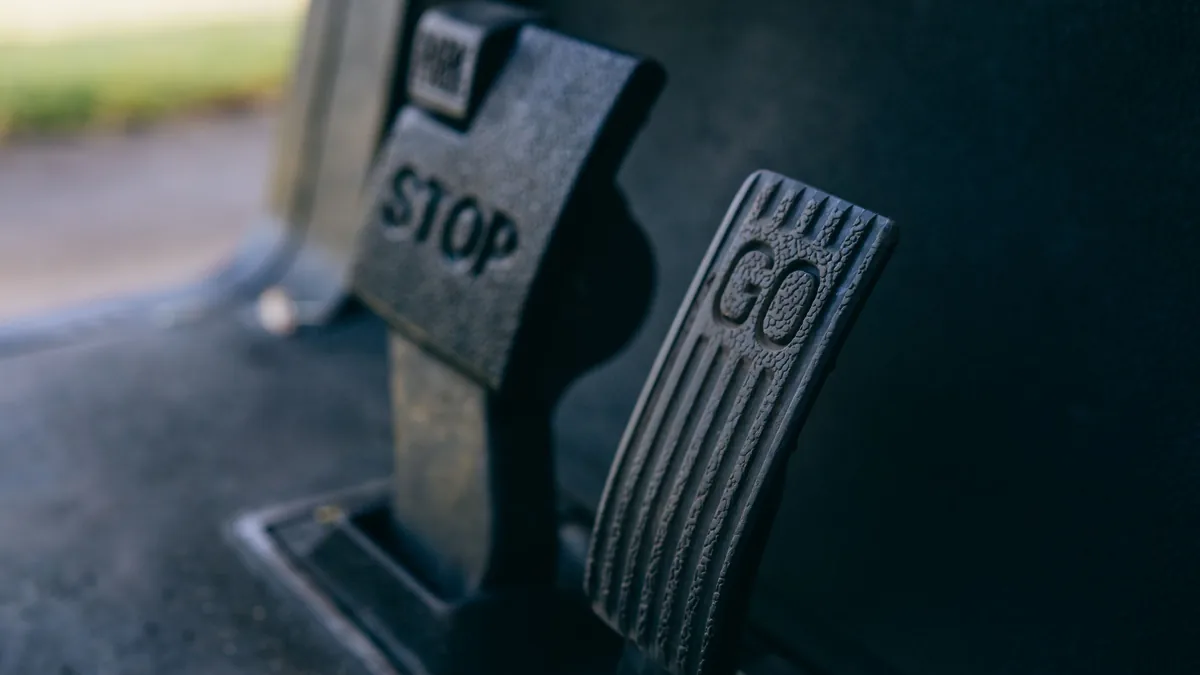 The gas and brake pedals in a car footwell, where numb feet can press the wrong pedal