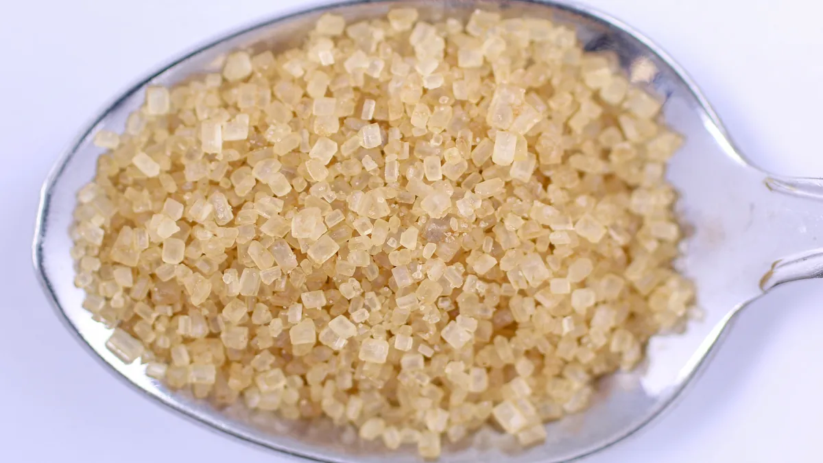 A spoonful of golden raw sugar crystals, the glucose that glycates and damages nerve proteins